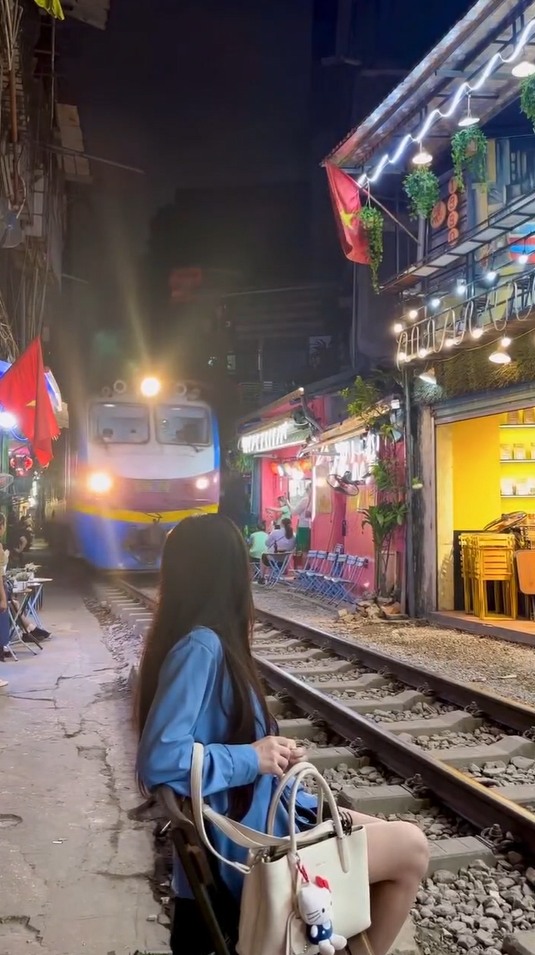 Có thể là hình ảnh về một hoặc nhiều người, cáp treo, tàu hỏa, đường phố và văn bản